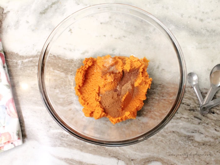 Adding pumpkin spices to pumpkin puree for an easy pumpkin Thanksgiving dessert.