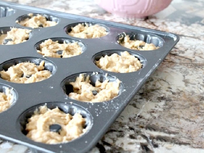 A donut baking pan filled with dough while making Christmas donuts.