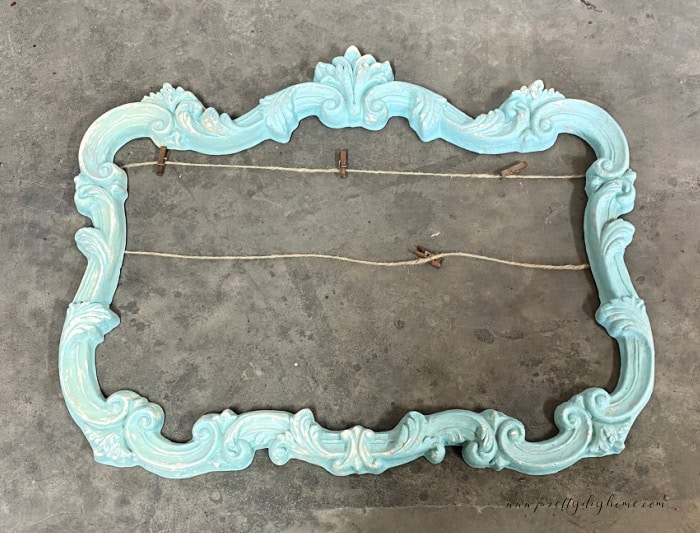 A garage sale elaborate frame, in bright bab blue. The befoe image of a halloween decoration chakj