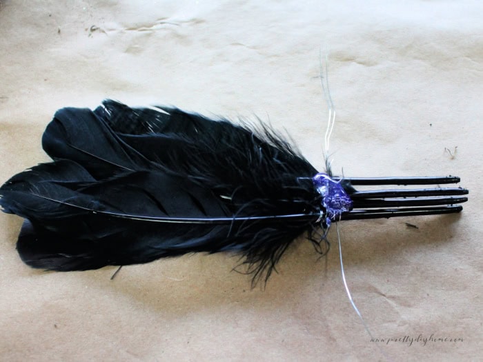Making a bundle of feathers tying them together with florist wire and hot glue.  Part of a DIY Halloween craft witch spindle project.