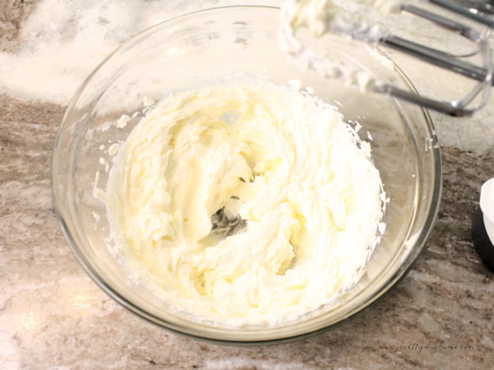 A bowl filled with whipped butter and whipped sour cream for making sour cream glaze.
