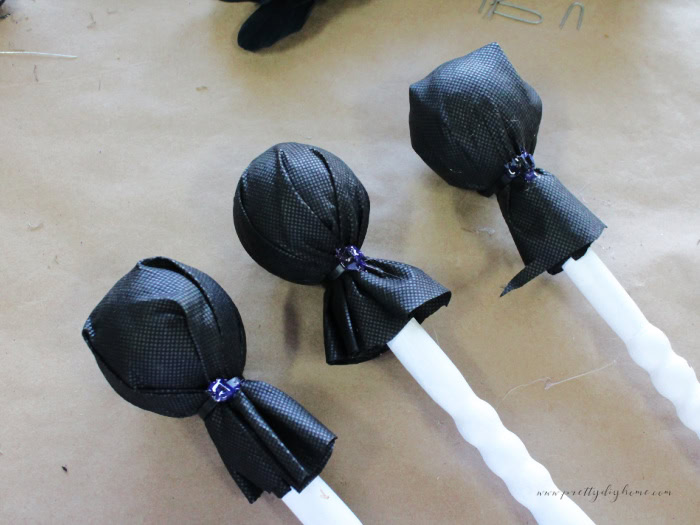 Three neutral black and white witch wand spindles with tops attached.  The witch sands are not decorated yet.