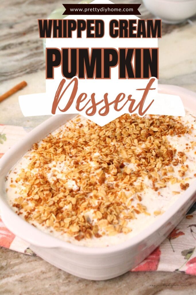 A white serving dish filled with pumpkin crisp with granola topping. Its an easy layered dessert served in a white ceramic baking dish. There is a fall tea towel under the dish.