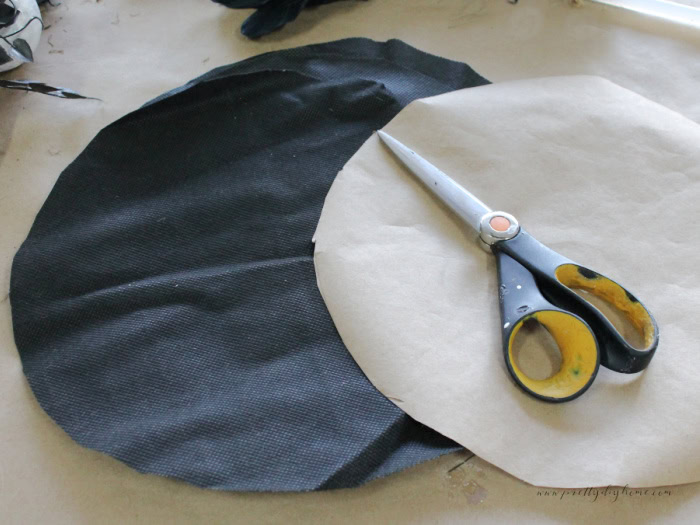 A circle paper pattern and cut fabric for the top of some Halloween spindles crafts turned into witch wands.