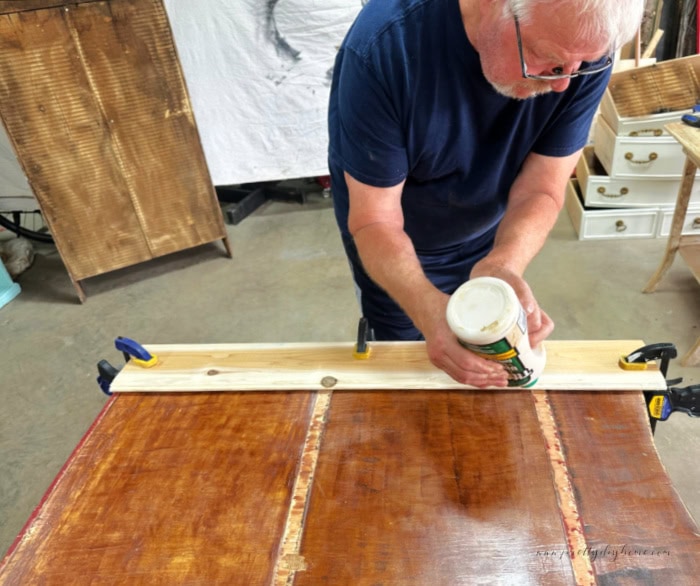 Adding the first piecd of tongue and groove to the back of the cabinet.