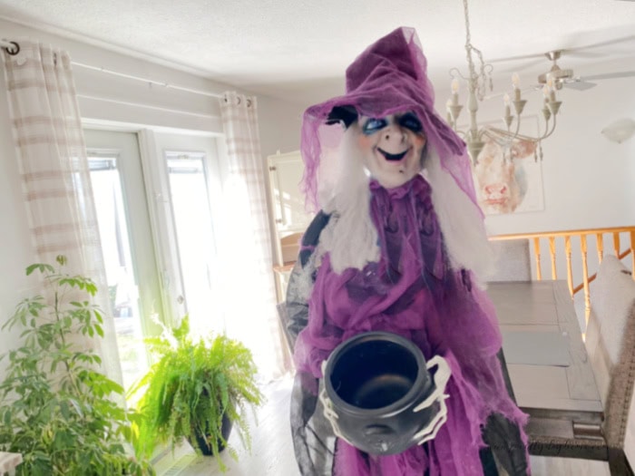 The before image of a garage sale with for Halloween, her bucket is empty, she has hair missing, and she is hanging from her new stand so she stands up.