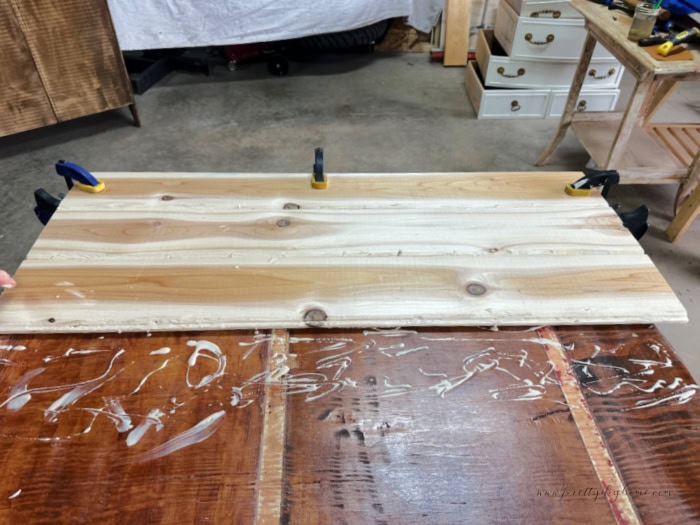 Fitting tongue and groove together for repairing a vintage solid wood cabinet.