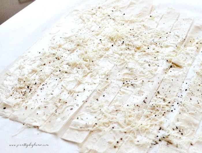 Sheets of phyllo pastry cut into strips and covered with parmesan cheese and ground pepper.