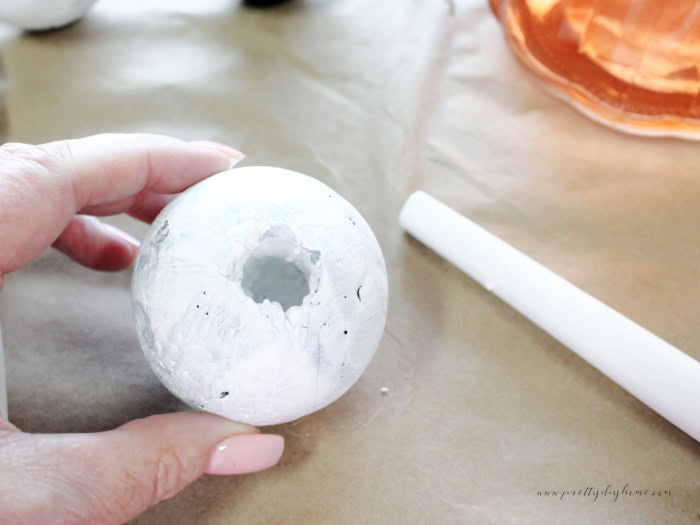 Making a hole to assemble a diy witch wand for Halloween.You can see the hole in the bottom of the styrofoam ball.