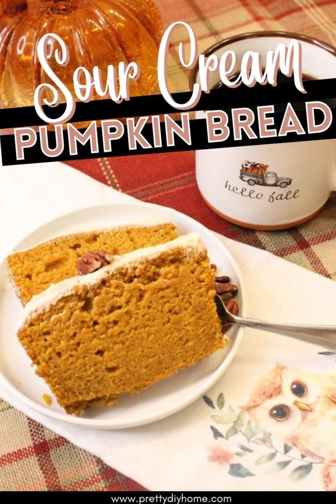 A white plate with two slices of homemade sour cream pumpkin bread with pumpkin glaze on top. The pumpkin bread is being served on a white plate with a fall themed mug full of coffee. The ackground is orange plaid burlap.