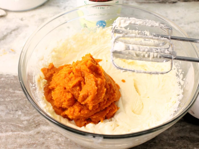 The wet ingredients for a pumpkin loaf recipe, their is a 2 cup portion of pumpkin puree being added to the bowl.