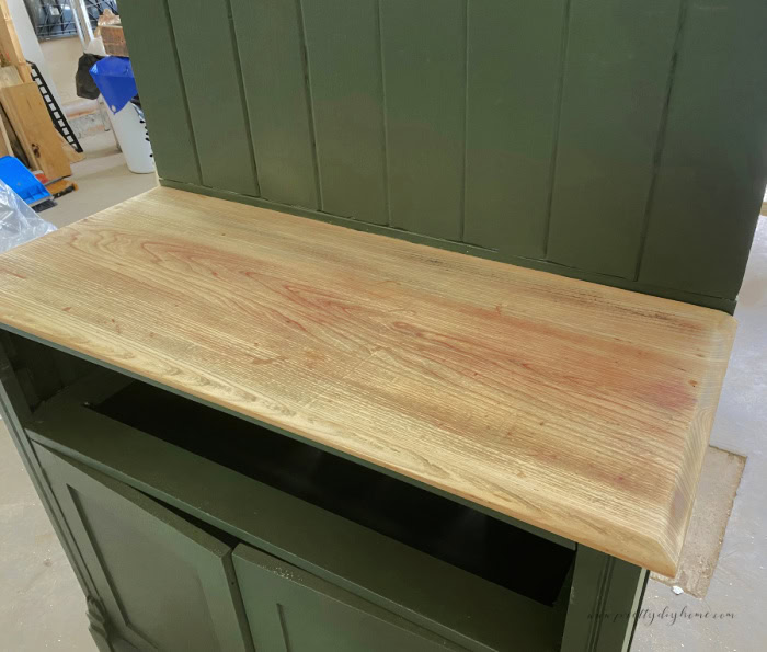 Attaching the refinished painted backing to the top of the dresser, before re-adding the shelves.