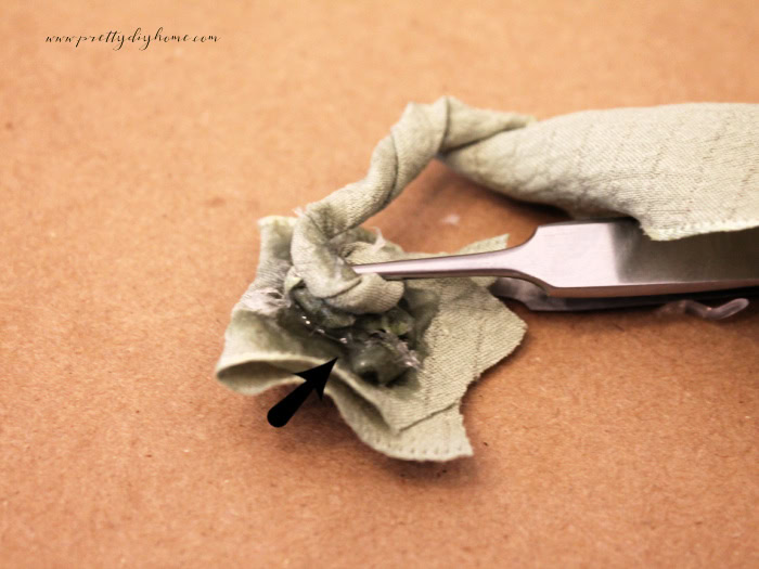Twisting a mint green ribbon into a rolled flower.
