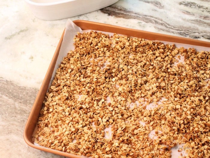 A cookie tray full of homemade cinnamon gingersnap granola cooling.