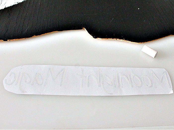 The backside of a word template being traced out with chalk for a letter transfer.