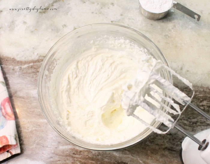 Beaten whipped cream in a clear bowl.