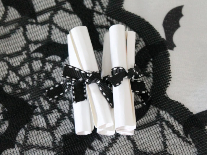 Rolled scrolls of the witch spells tied with black ribbon.