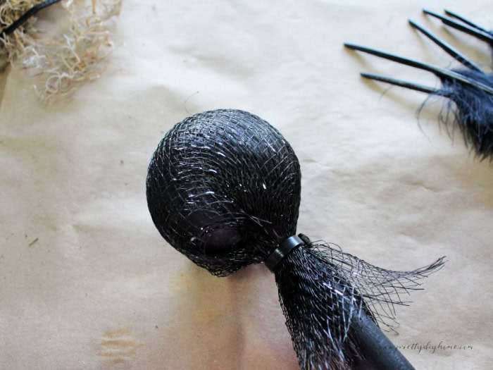 Dollar Tree Halloween mesh wrapped around a styrofoam ball and secured with a pull tie.  It will become the end of a Halloween witch wand.