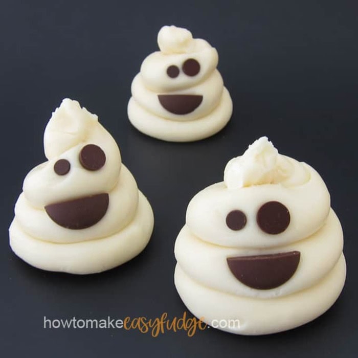 Three cute ghosts with chocolate chip eyes and the ghosts are made out of fudge.  Each one is sitting on a black board.