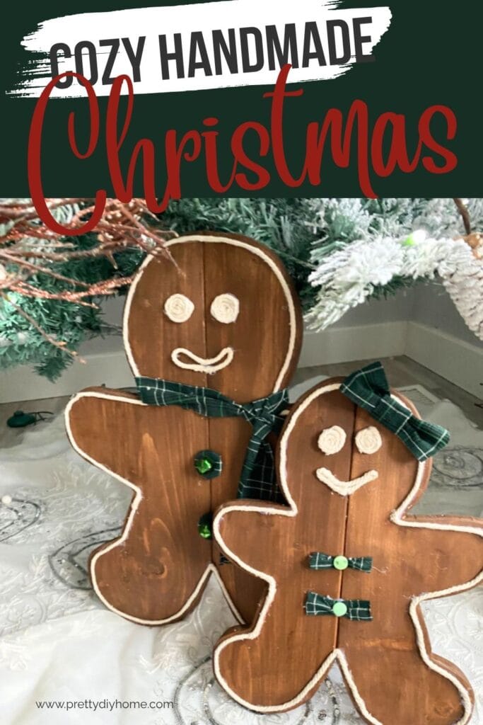 Two large wood gingerbread people one male and one female. They are standing underneath the Christmas tree for inexpensive rustic DIY Christmas decorations.