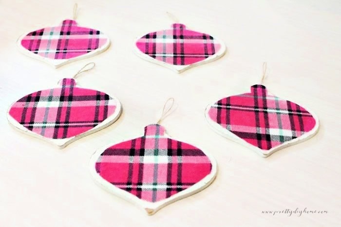 Five simple DIY pink flannel Christmas ornaments shown together before hanging on the tree.
