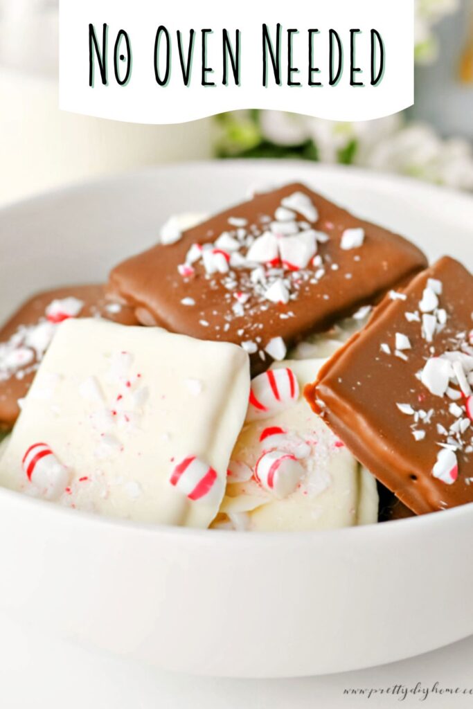 A  bowl filled with chocolate covered graham crackers some with white chocolate some with milk chocolate.  Then covered with crushed peppermint.