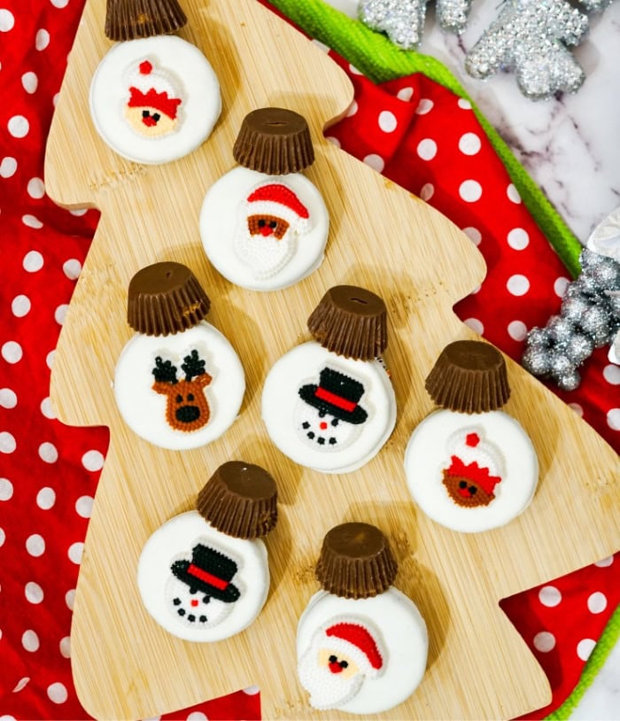 Seven different white chocolate covered oreos with adorable predone Christmas themed candy fronts. An easy no bake Oreo Christmas treat idea.