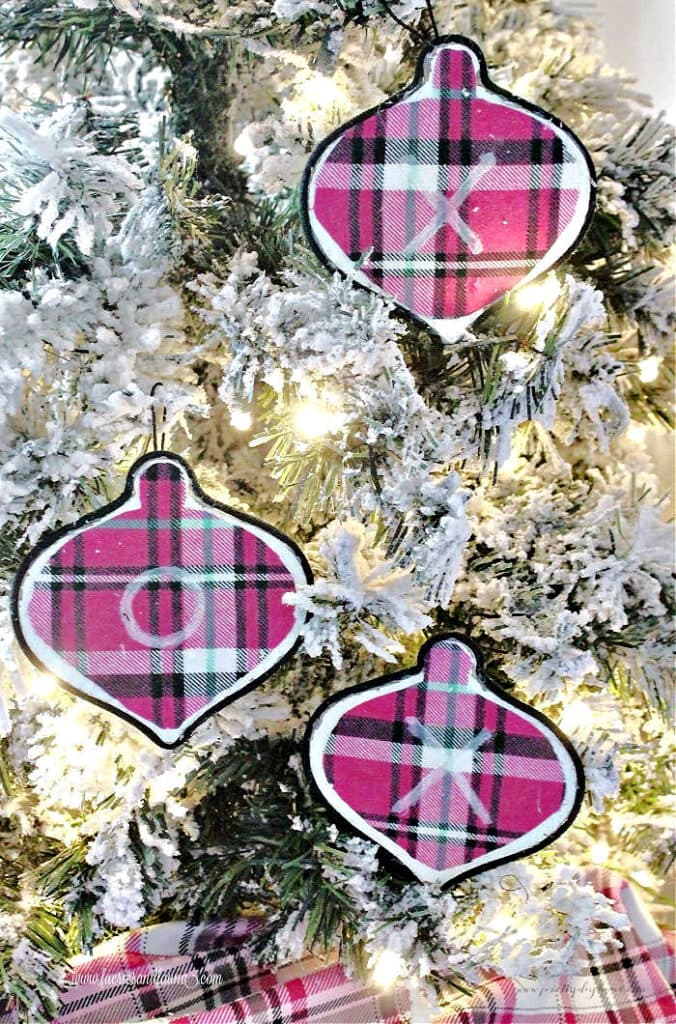Three pink flannel DIY Christmas ornaments hanging on a small Christmas tree in a girls bedroom.