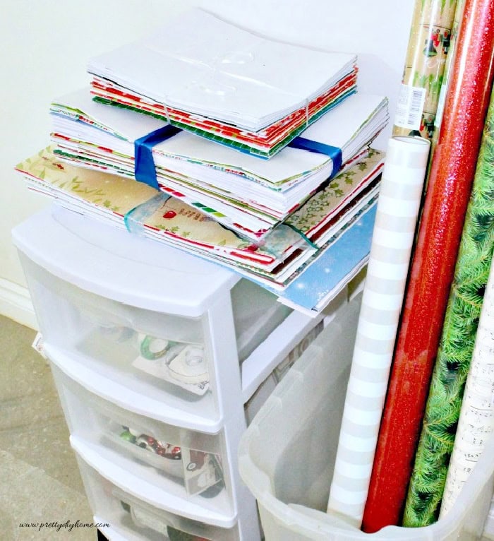 Stacked Christmas gift boxes in neutral paper sitting on top of a wrapping station, ready for wrapping season