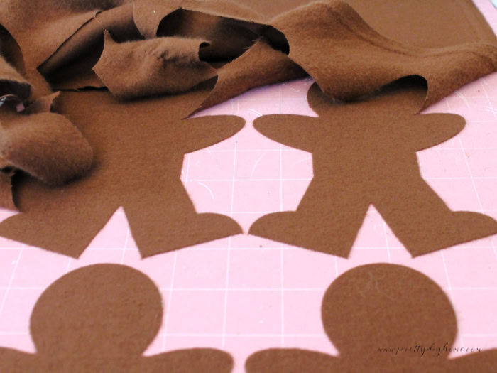 Showing how to weed fabric from a gingerbread men design cut with Cricut .