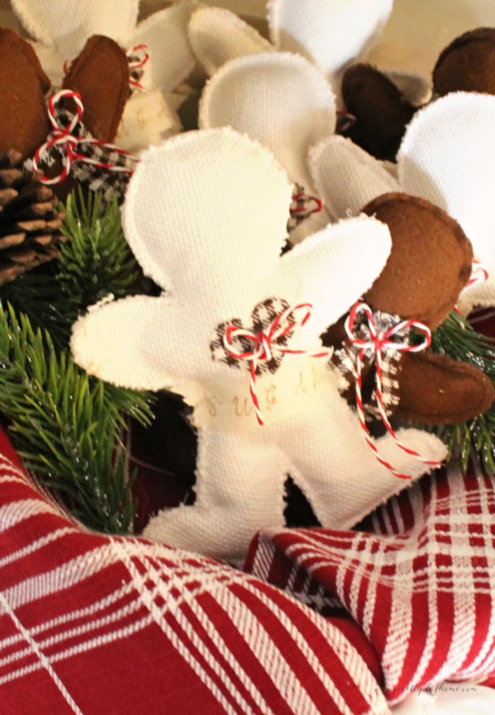 White and brown fabric gingerbread men decorated with homespun heart, sarces, and baking twine,