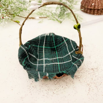 Lining a tart tin ornament with tartan fabric to create a cozy cottage-style Christmas decoration.