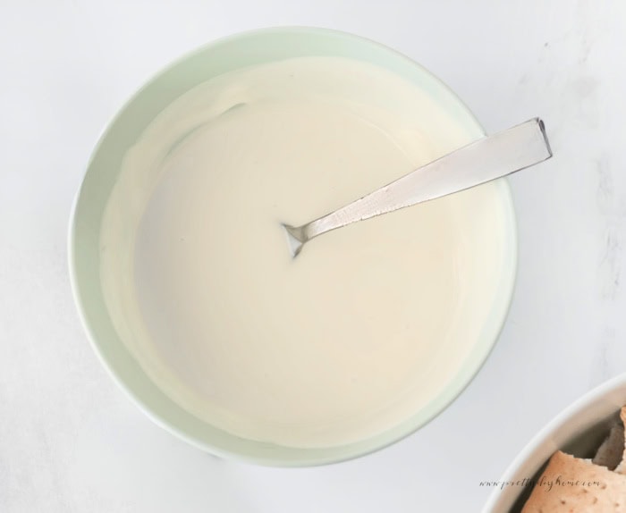 Bowl of melted white candy coating for Christmas chocolate covered graham crackers.