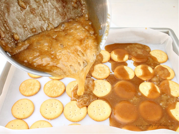 Pouring hot toffee over Ritz cracker base.