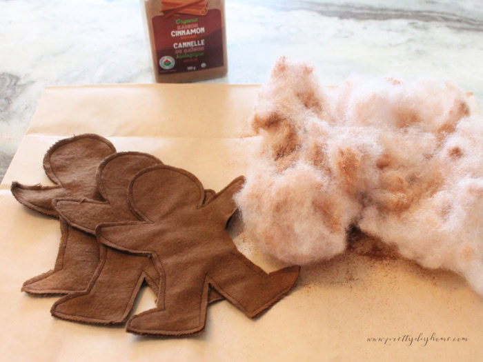 Mixing ground cinnamon into poly-fil to scent fabric gingerbread men before stuffing.