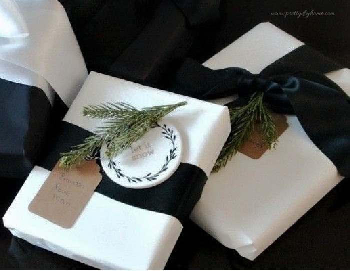 White paper Christmas present wrapping idea with black satin ribbon and long bow tails.