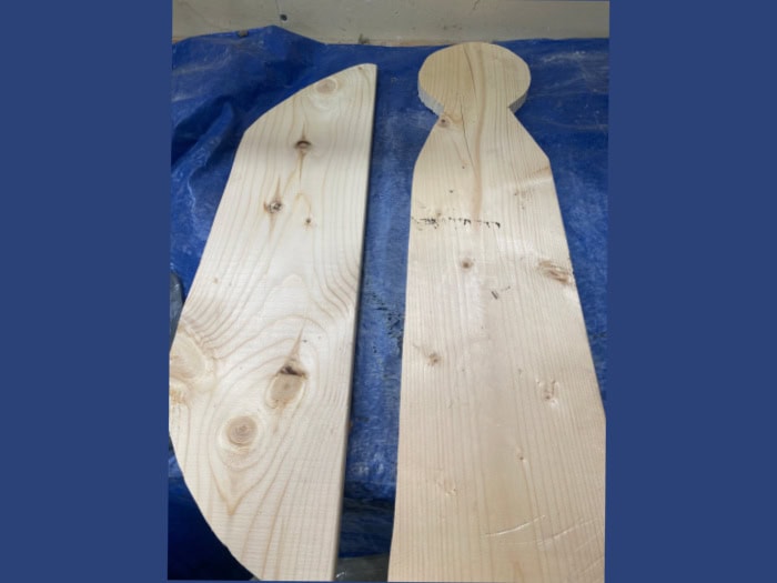 Cut wooden angel pieces made from 1×6 scrap lumber, including the body and wings, before painting and assembling.