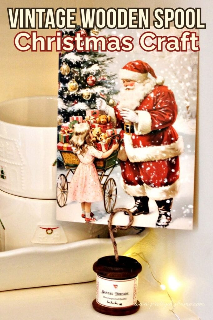 Close-up of a Santa postcard displayed in a wire holder made from a wooden thread spool., you can see that label that says santas threads.