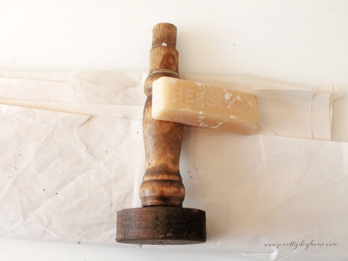 Spindle with new base attached showing vertical wax lines for creating natural distressing.