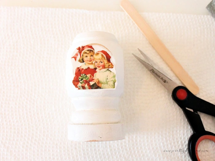 Rub-on Christmas transfer cut out and placed on the spindle with scissors and transfer stick nearby.