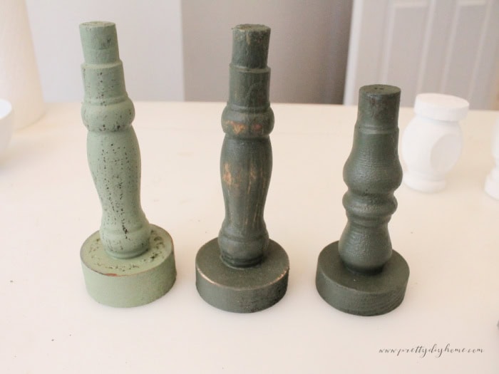 Three distressed green spindle bases in different heights, painted in Bayberry and Conservatory.