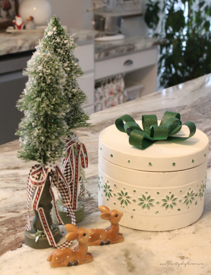Green bottle brush trees attached to distressed green spindle bases.