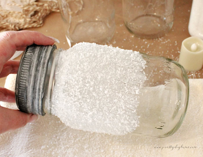 Mason jar covered in Mod Podge and Epsom salt to create a frosted Christmas look.
