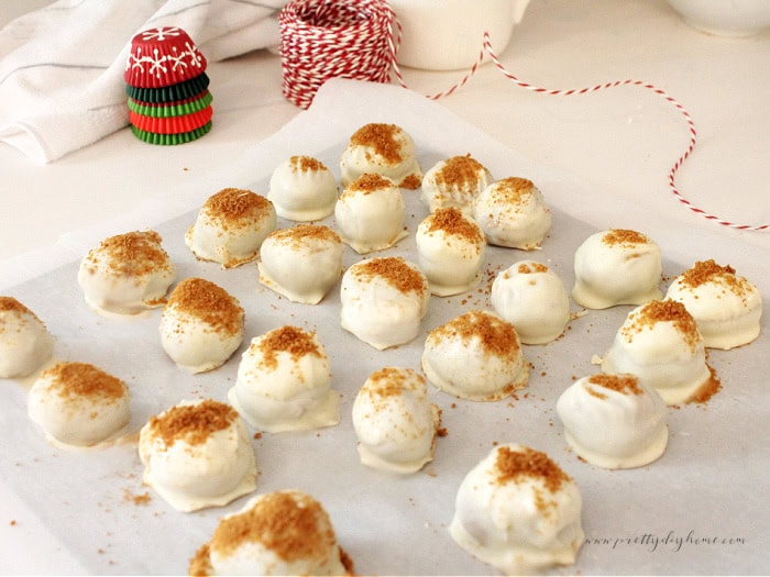 No-bake gingerbread truffles cooling on parchment paper sprinkled with cookie crumbs