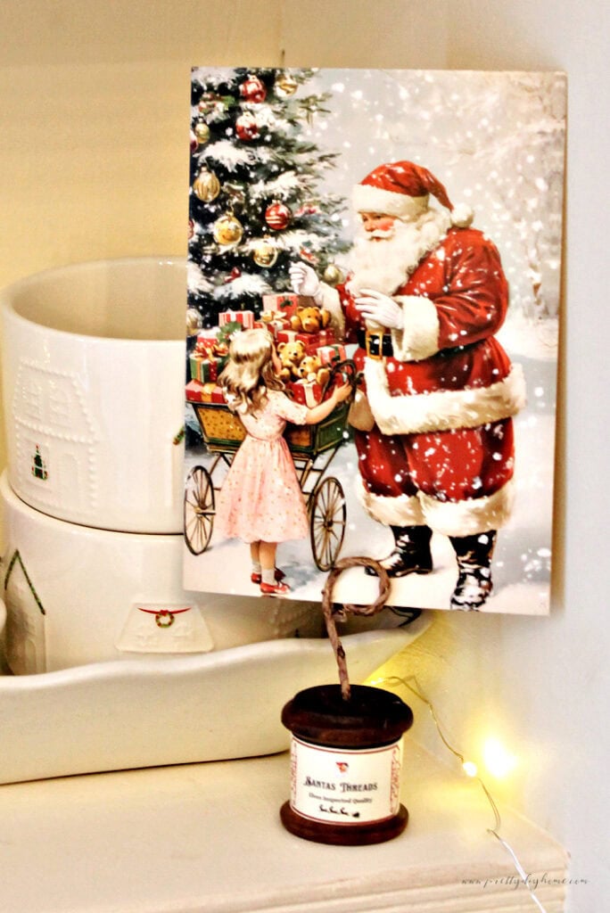 Finished wooden spool postcard holder with a santa postcard and vintage Christmas display.