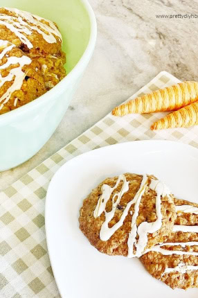 Recipe for carrot cookies, showing two cookies on a plate drizzled with white icing.