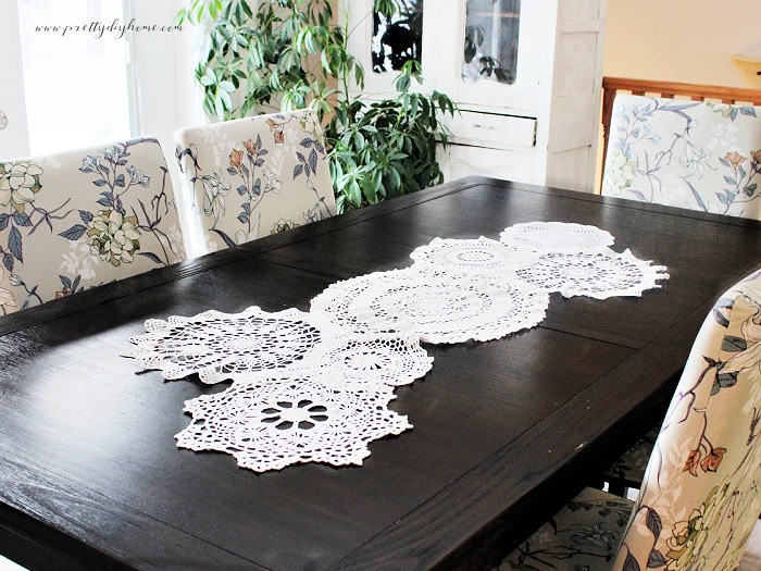 Finished doily craft table runner styled on a dining table with vintage chairs and no centerpiece