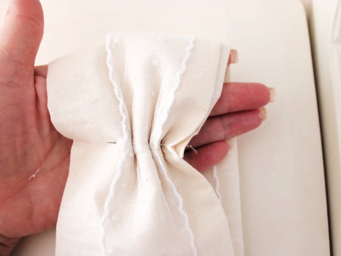 Gathering fabric bow loops and sewing them in place from the back