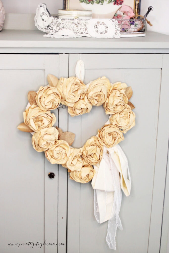 Close up of a paper bag rose wreath hanging from a dresser