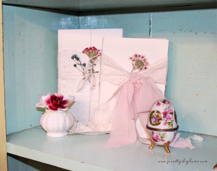 Decorative book stacks wrapped in lace and ribbon styled together as vintage home decor